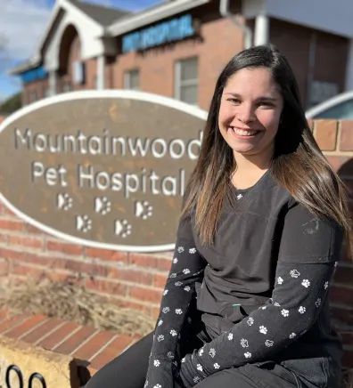 Tyra sitting next to the Mountainwood Pet Hospital sign
